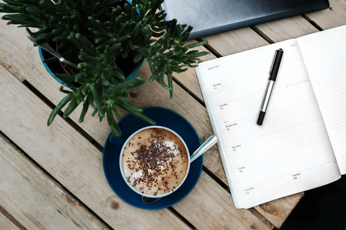 latte on desk with plant and planner