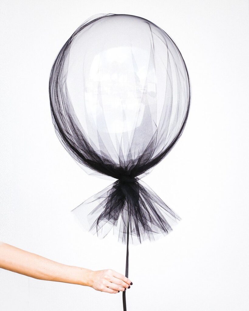 hand holding a black lace balloon