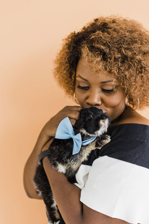girl in photo holding rabbit in front of orange screen