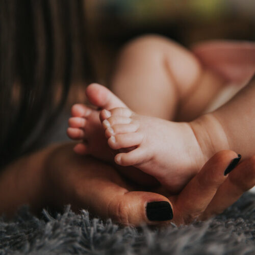 mom holding baby feet