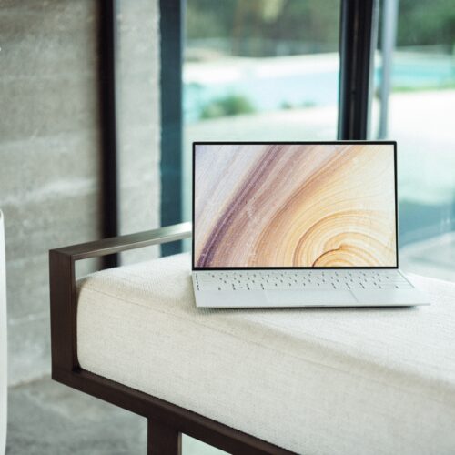 silver laptop on brown wooden table